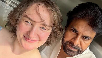 Happy young woman with short blonde hair smiling alongside a man with dark hair and beard outdoors.