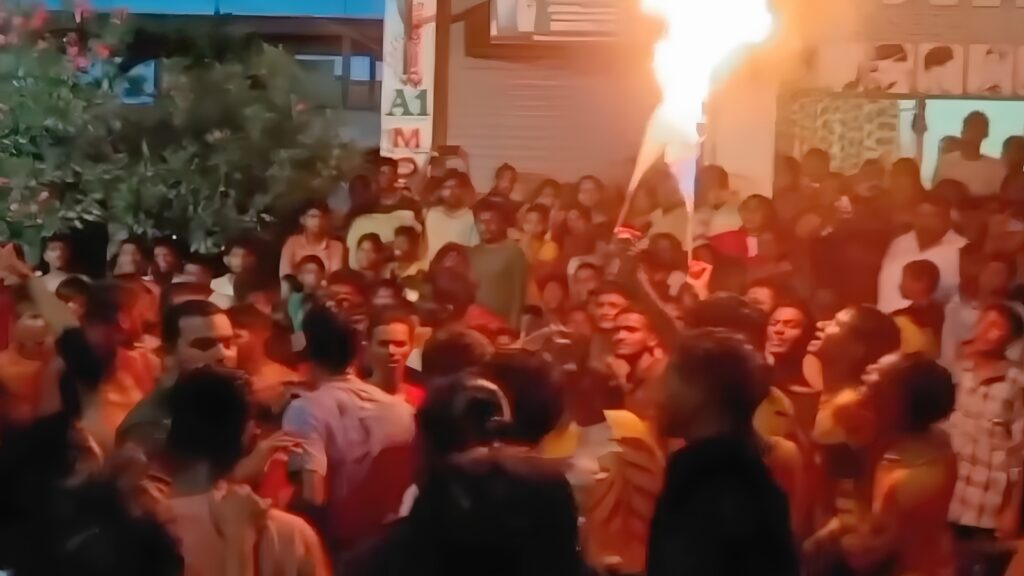 Crowd celebrating Peddapuli Panduga with firecrackers and traditional attire.
