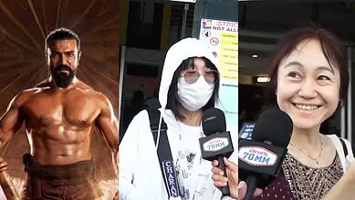 A muscular man being interviewed at Siasat Daily event, with a woman in a mask and another smiling woman.