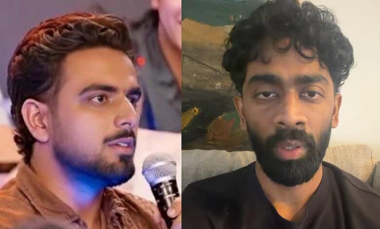 A young man with curly hair and a beard speaking into a microphone at an event.
