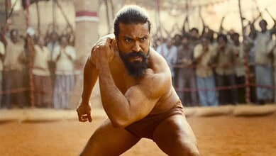 A man with a beard and long hair, dressed in traditional Indian attire, running in a historical or cultur.