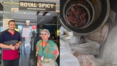A man and woman standing outside Royal Spicy restaurant, with a bowl of cooked meat on the table.