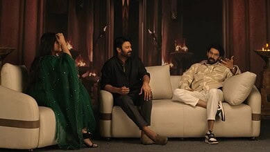 Prabhas and Rana Daggubati sitting on a sofa during a casual event or interview.