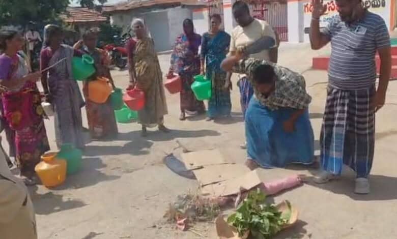The image shows the villagers of Yellareddypet in Thoguta mandal of Siddipet district protesting with empty pots and state government's effigy for not supplying drinking water to their locality for the past one week.