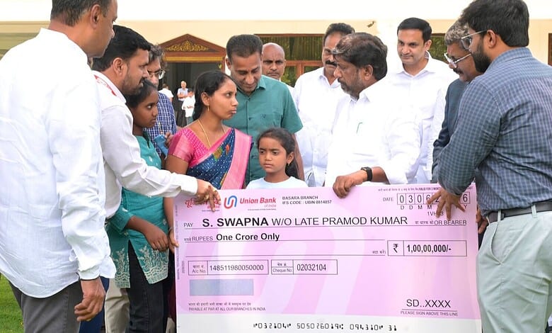 S. Swapna receiving a cheque from officials at a formal event in India.