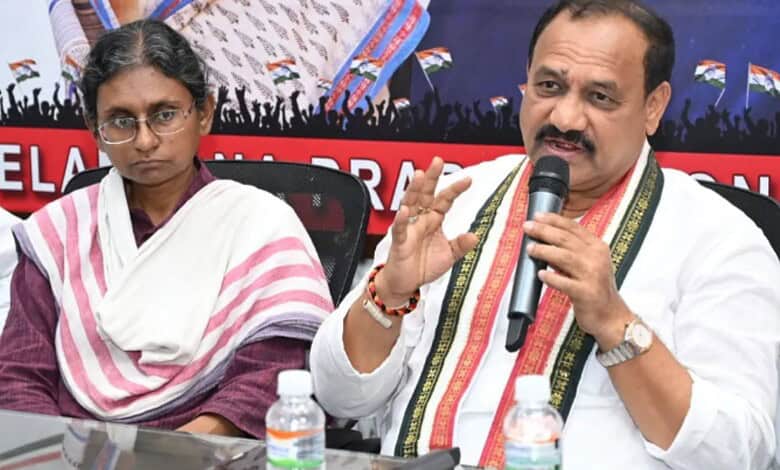 TPCC chief speaking into microphone during a political event with a woman beside him.