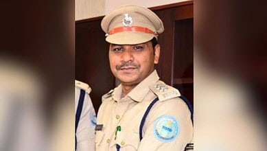 Bhupalpalli DTO in police uniform with badge and cap, smiling at camera.
