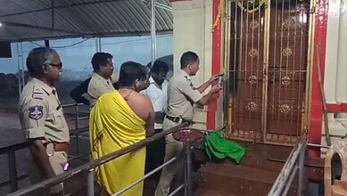 Police officers and a woman in yellow observing the temple door at Mahankali Temple, Basar.