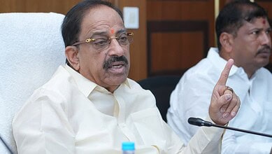 Tummala gesturing with his finger during a discussion at a formal meeting.