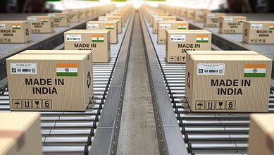 Made in India cardboard boxes on a conveyor belt in a warehouse.
