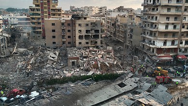 Urban area damaged by fire with collapsed buildings and debris, emergency responders on site in a citysca.