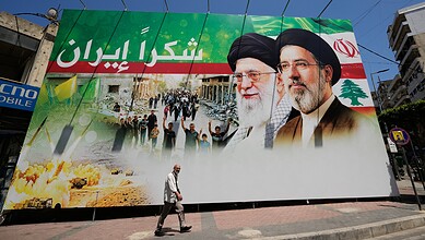 Large billboard in Iran showing leaders and patriotic imagery with Persian text.