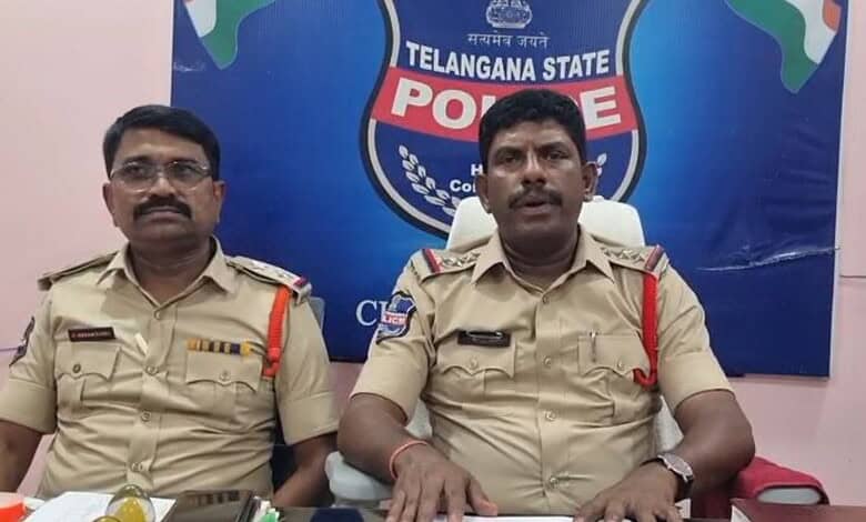 Police officers from Telangana State Police sitting at a press conference with a Telangana State Police b.