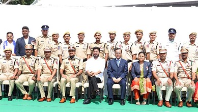 A diverse group of police officers and officials posing for a formal photo outdoors.