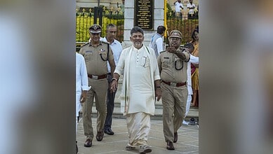 Indian politician walking with police officers outside a government building in India.