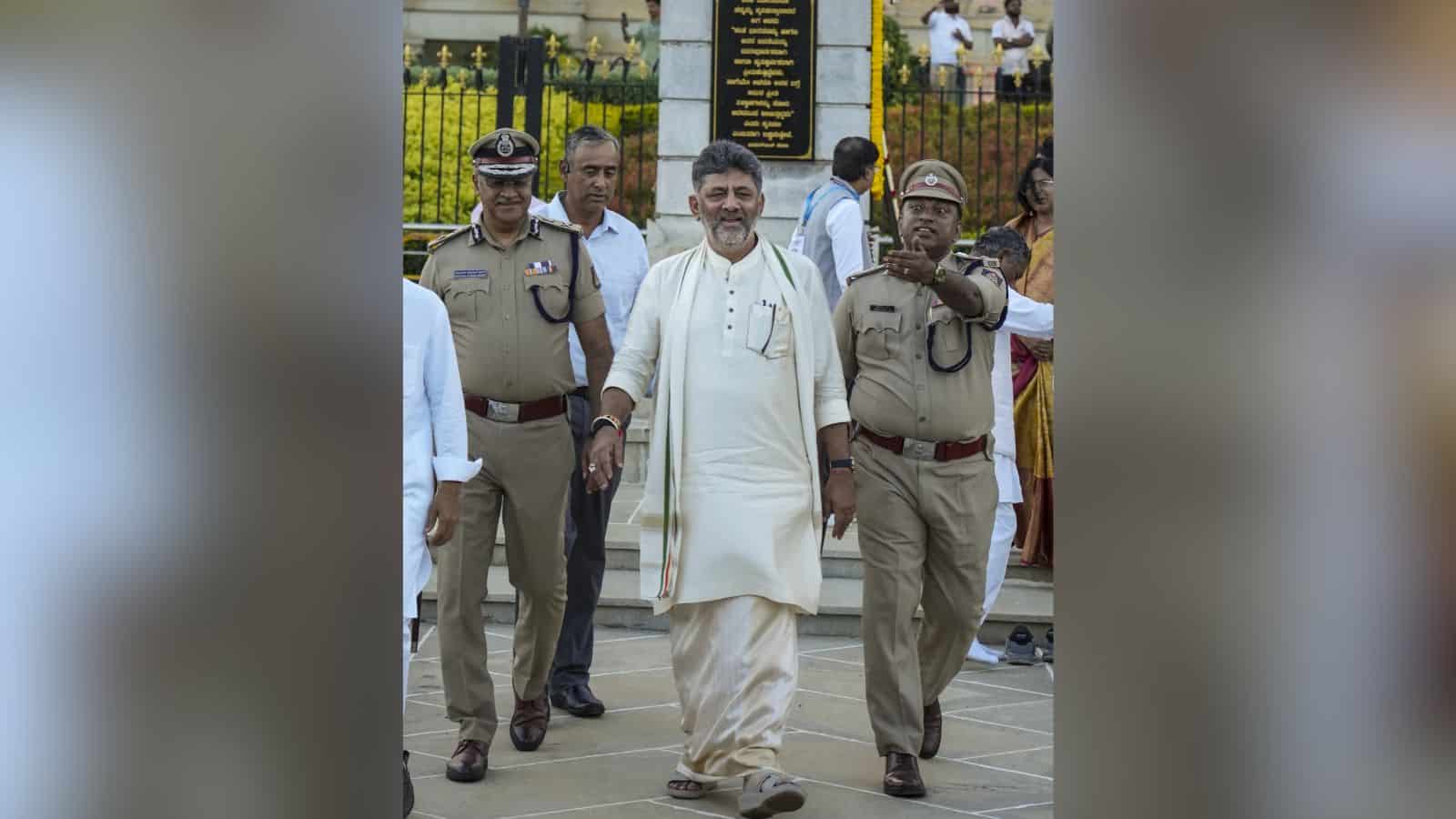 Indian politician walking with police officers outside a government building in India.