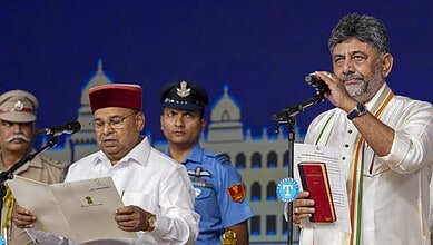 A man in traditional attire speaking at a podium with police officers in the background during a formal e.
