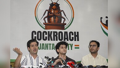 Three men speaking at a press conference about cockroach control in Gujarat, India.