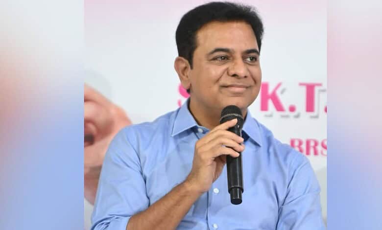 A man in a blue shirt speaking into a microphone at a public event.