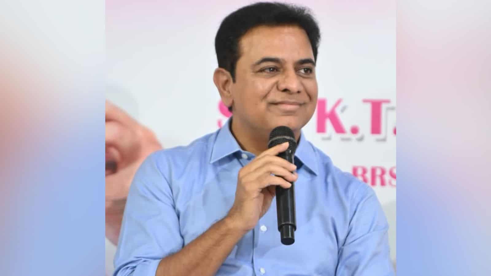 A man in a blue shirt speaking into a microphone at a public event.
