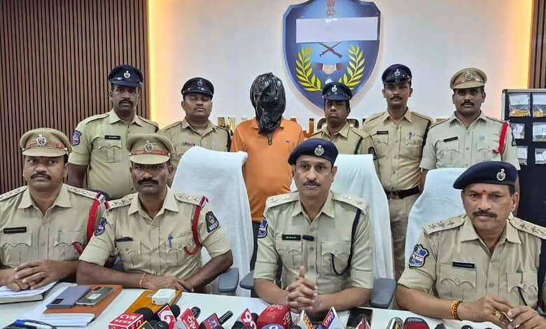Arrested suspect in police custody with officers during a press conference at Siasat Daily.