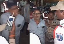 A man being detained by police officers at night, with officers holding a mobile device and engaging with.