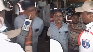 A man being detained by police officers at night, with officers holding a mobile device and engaging with.