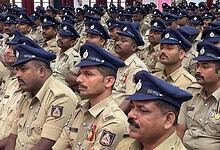 Police officers in uniform attending a formal event, standing in formation with serious expressions.