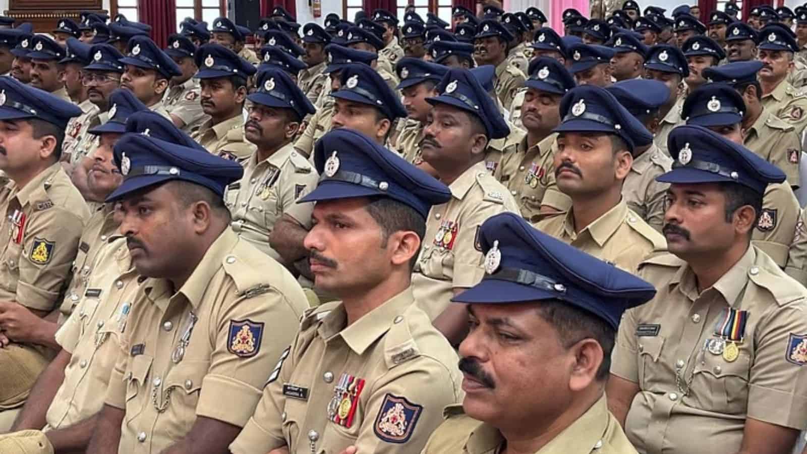 Police officers in uniform attending a formal event, standing in formation with serious expressions.