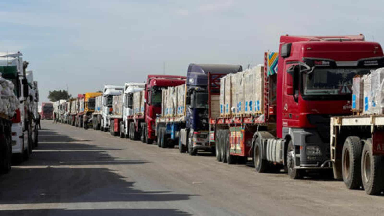 A line of various trucks parked along a road, ready for transportation or delivery.