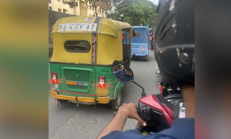Auto rickshaw on busy city street with motorcycle rider in foreground, vibrant urban scene in the backgro.