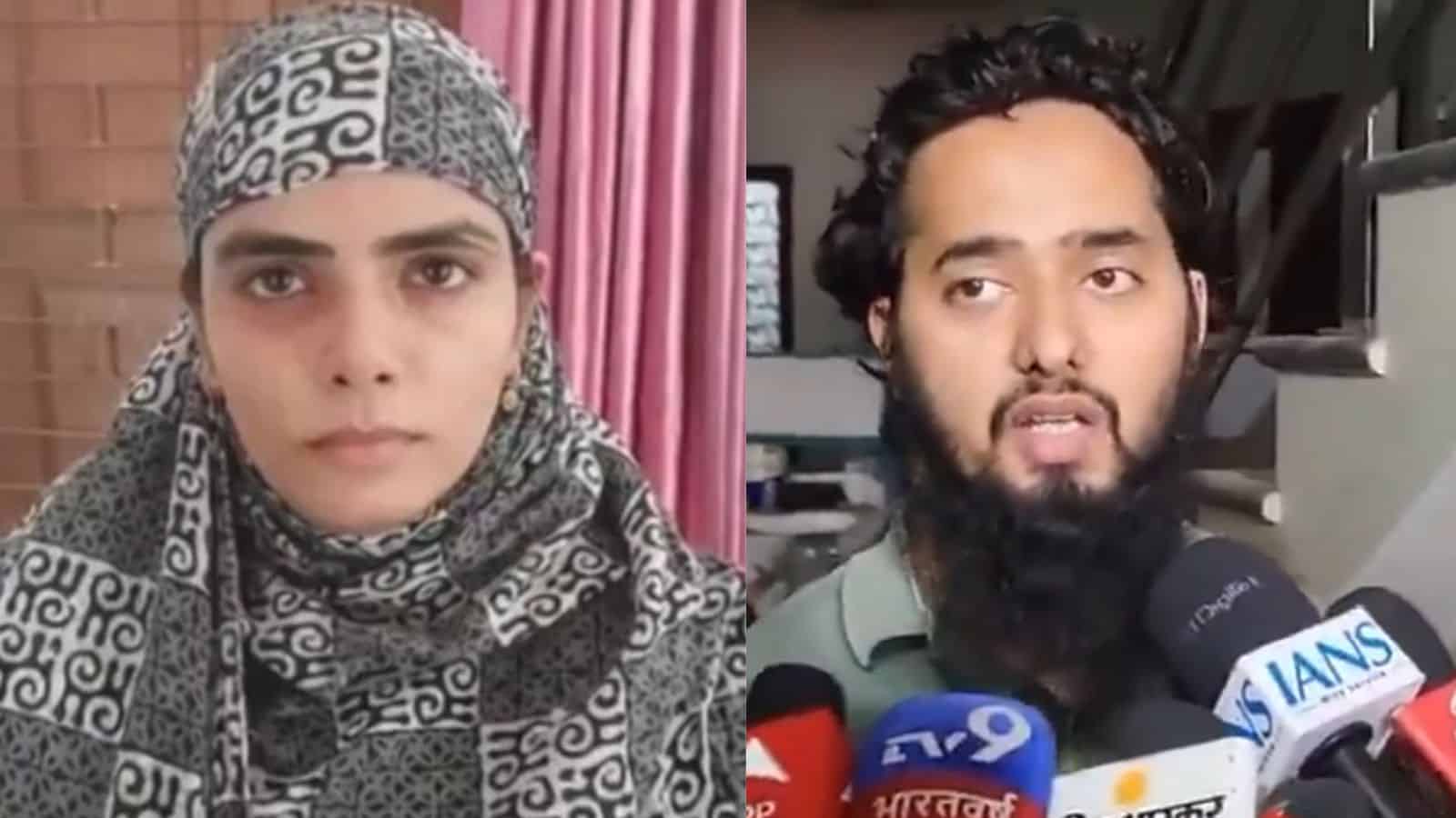 A woman wearing a patterned headscarf and a man with a beard speaking to the media with multiple micropho.
