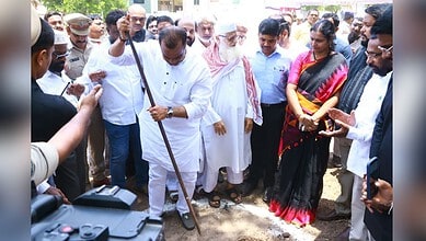 Prominent Indian politician participating in a public event with diverse crowd and media coverage.