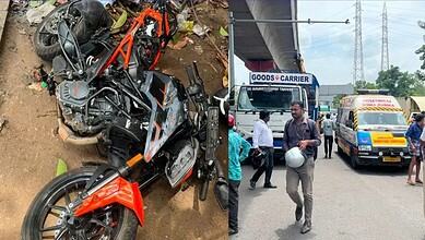 Motorcycle crash scene with damaged bike and bystanders at roadside in India.