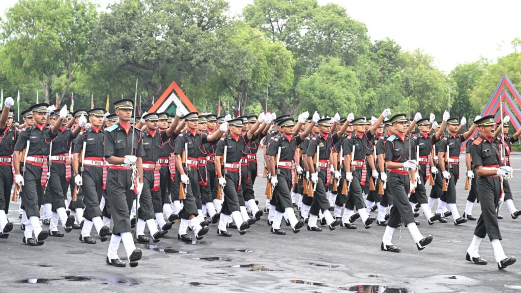 Military parade with soldiers in uniform marching in formation during a public event in India.