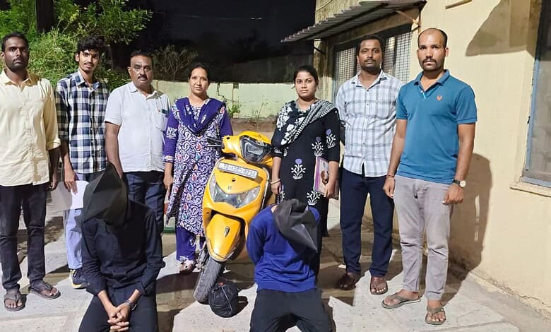 Group of eight people standing outdoors with a yellow scooter in front, sunny day, casual attire, diverse.
