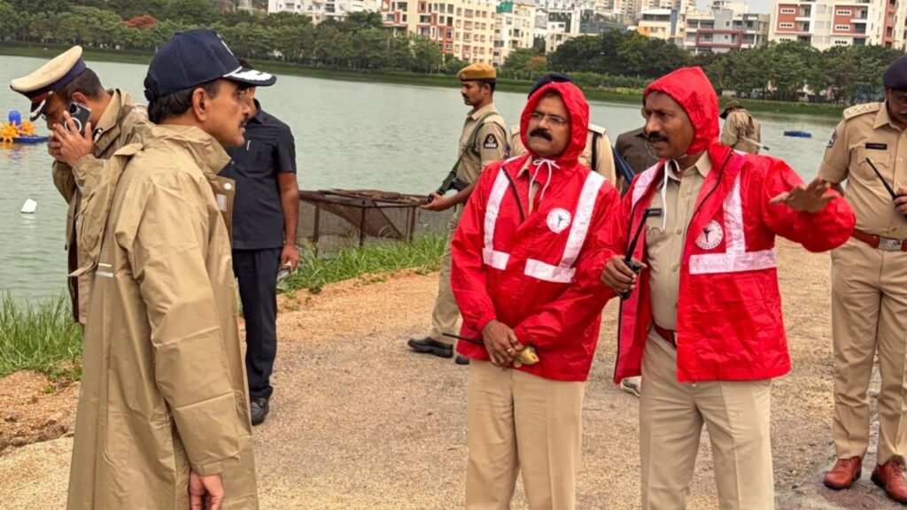 Police officers and rescue workers by the riverbank during an emergency response in India.