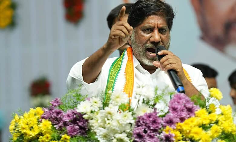 Politician speaking passionately at a public event with flowers in the background.