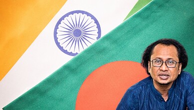 Indian diplomat with Indian and Bangladeshi flags in the background.