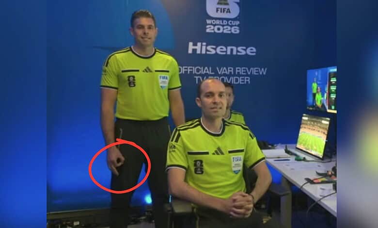 Referee with hand gesture during World Cup match, monitored for racism issues.