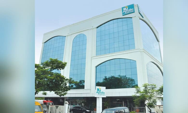 Modern Apollo Hospitals building with glass facade and greenery in front.