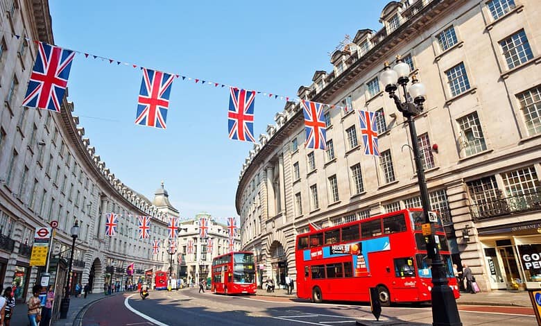 London street decorated with Union Jack flags and red double-decker buses.