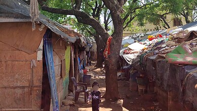 Rohingya children in Hyderabad amidst makeshift shelters and scattered belongings.