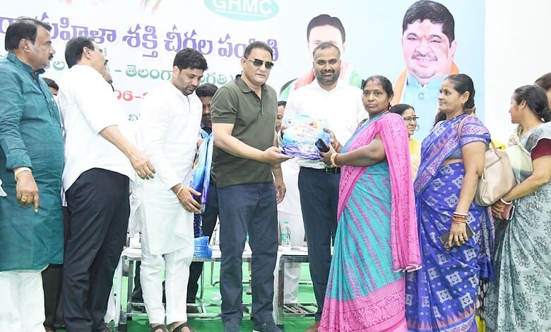 Mohammed Azhruddin hands over a saree to a woman at a programme in Hyderabad