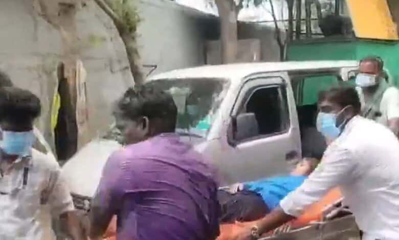People wearing masks assist an injured person on a stretcher after a gas leak incident.