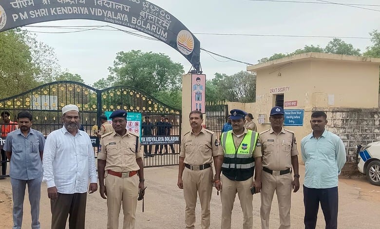 Group of police officers and officials standing outside PM Shri Kendriya Vidyalaya school in Bolarum.