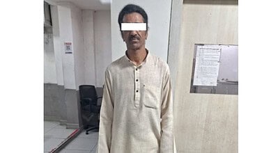 Man in beige kurta with white background, detained by police in Hyderabad.