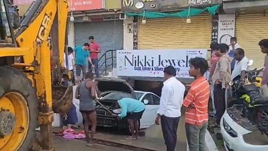 A car is being pulled out of a cellar using JCB