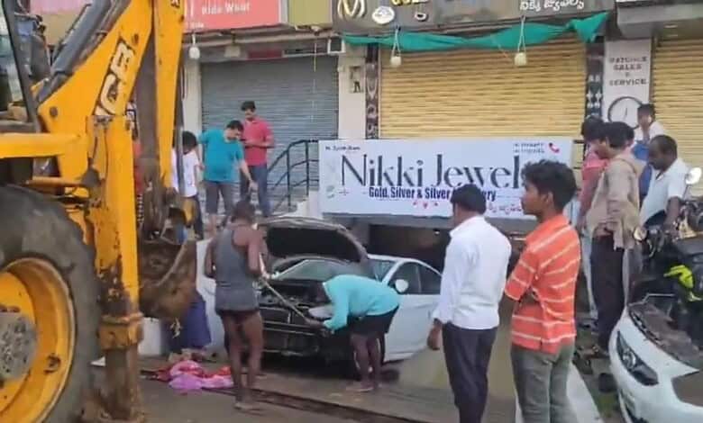 A car is being pulled out of a cellar using JCB