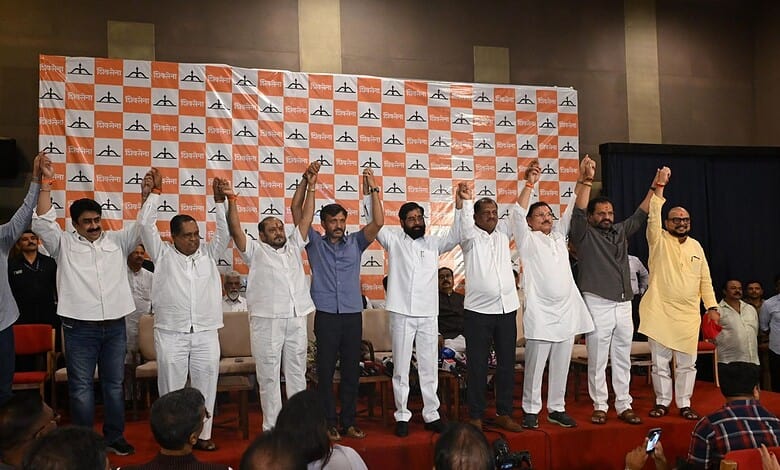 Political leaders on stage celebrating with raised hands at a public event.